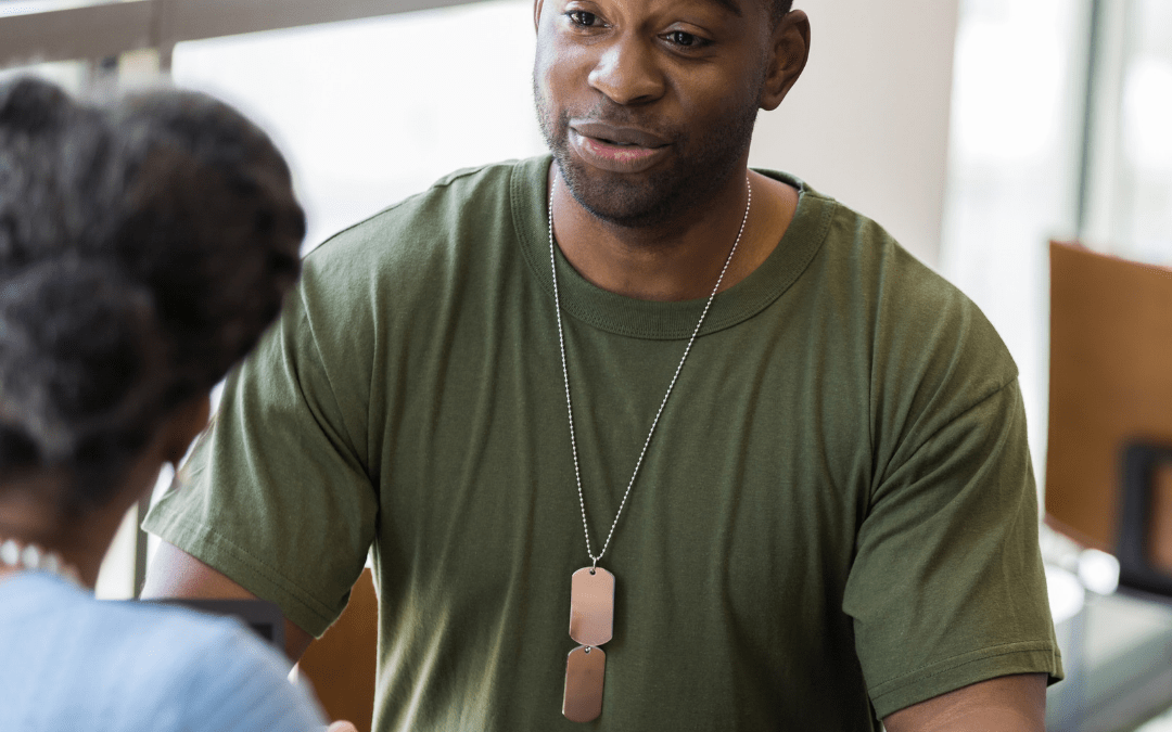 A veteran service officer wearing dog tags speaks to a woman