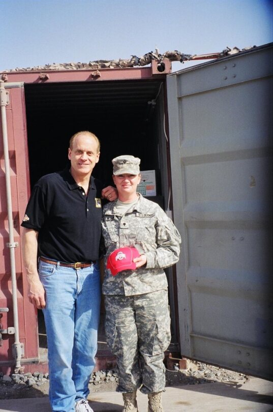 Randy Gradishar with military personal with ohio state hat infront of storage container