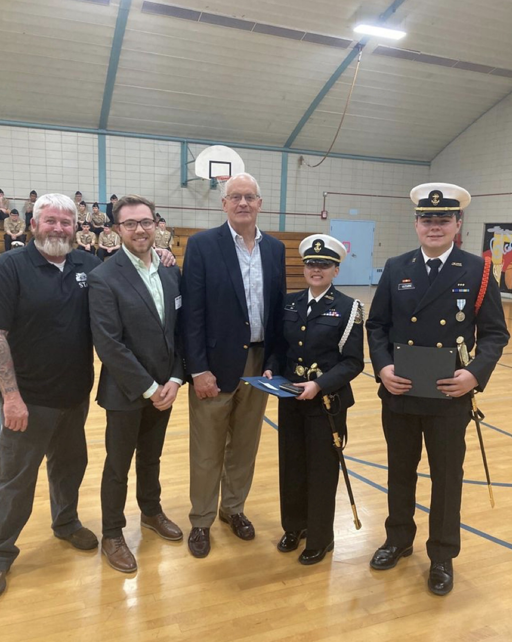 Randy Gradishar at high school gym with students in ROTC uniform