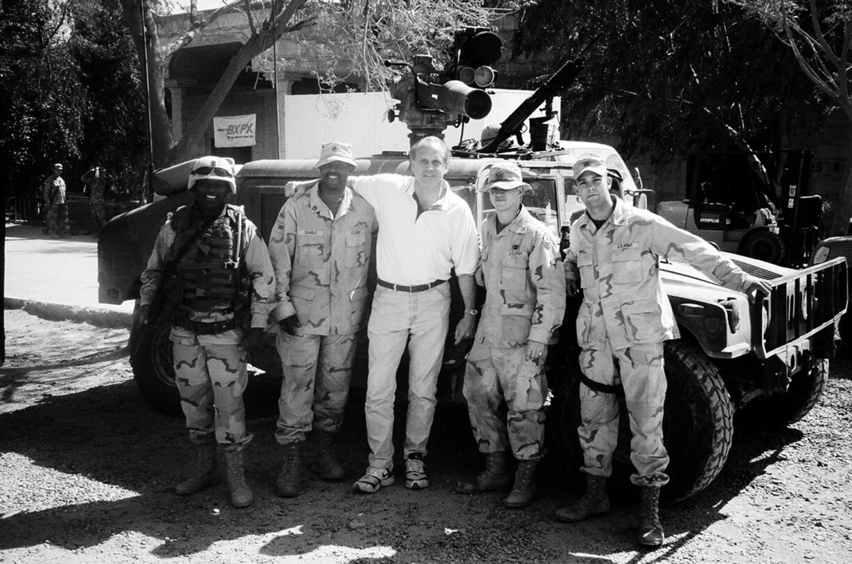 Randy Gradishar with military personal in uniform with military vehicle