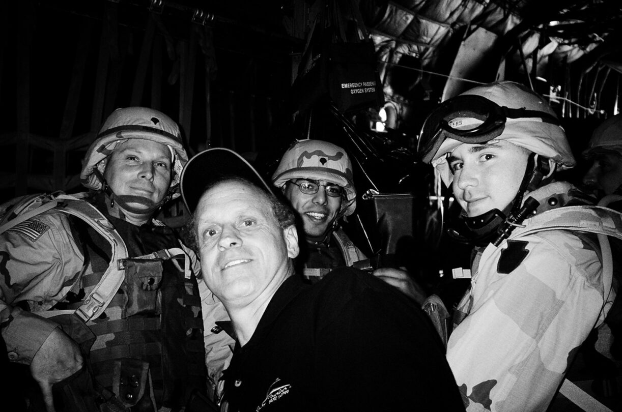 Randy Gradishar with 3 military personal in uniform on a plane